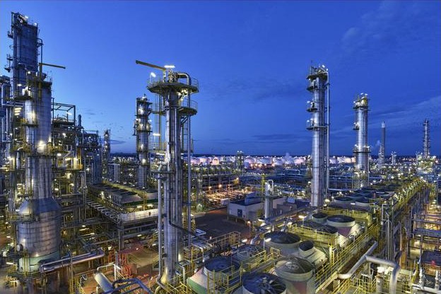 Refinería iluminada al anochecer